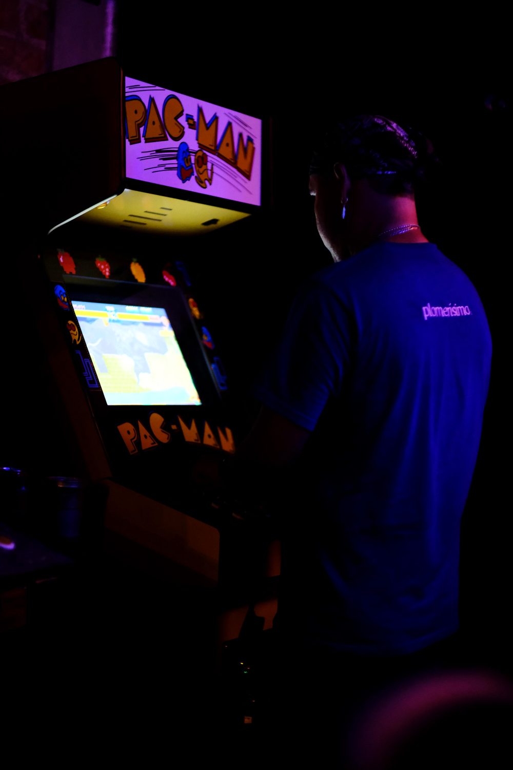 Una persona jugando en la máquina de Pac-Man